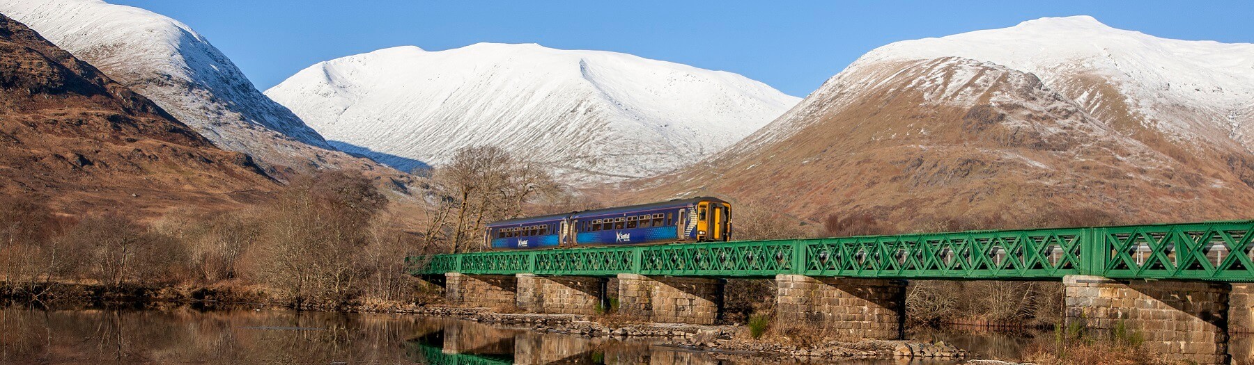 ScotRail train crossing bridge at Loch Awe in winter