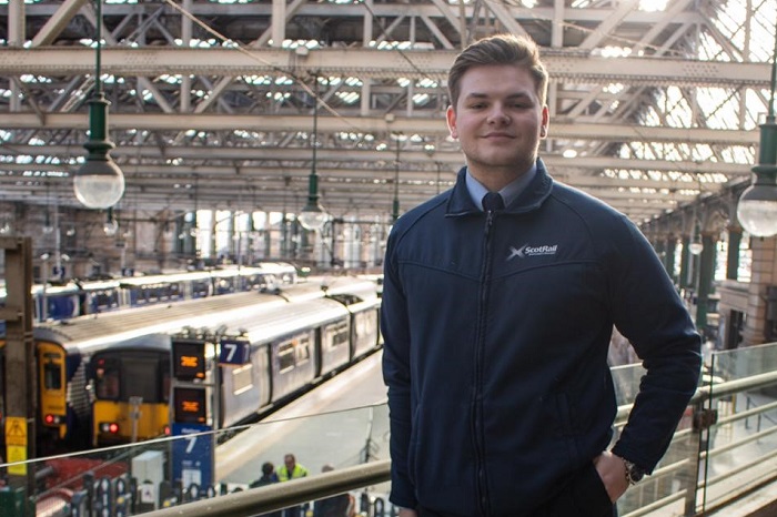 Lewis, customer service apprentice standing in Glasgow Central station