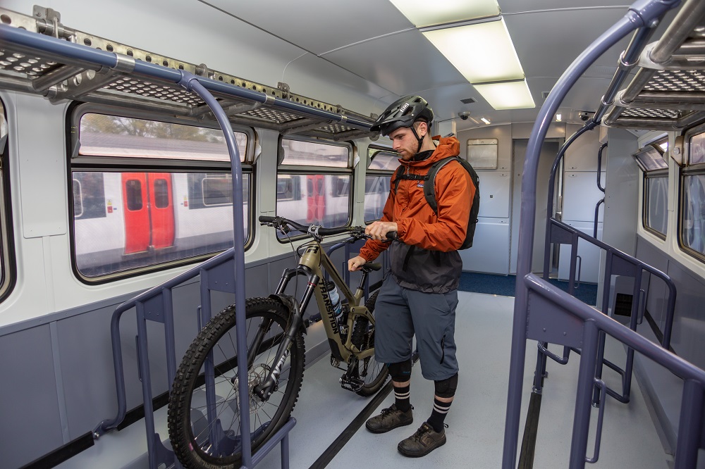 A cyclist wheeling his bike into the fixing loop on the Highland Explorer carriage