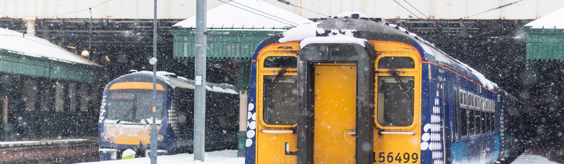 Snow on trains at a station