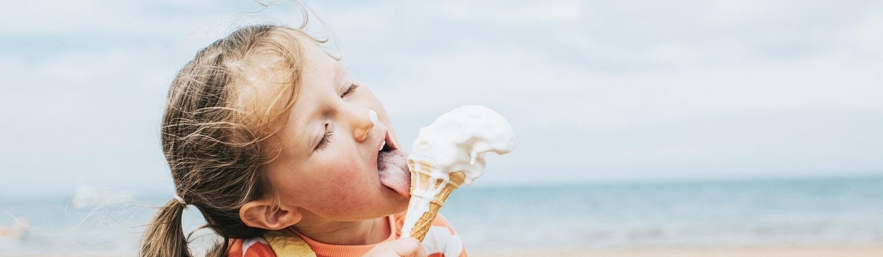 Little girl eating an ice cream at the beach