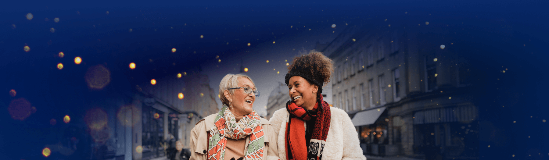 Older ladies walking in the city, smiling at each other, carrying Christmas shopping