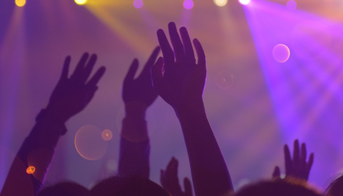 People at a concert with arms in the air