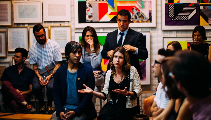 Group of people having a discussion with art on walls behind them