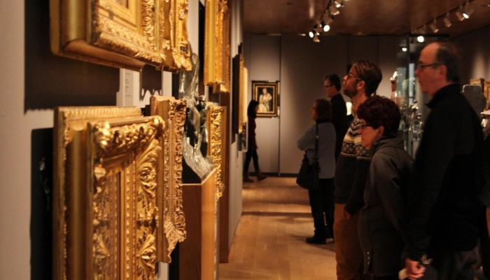 Patrons looking at art in gold frames