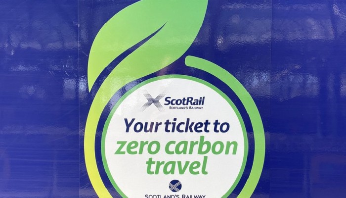A leaf shaped logo on a ScotRail train which reads "Your ticket to zero carbon travel"
