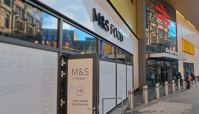 Image of the exterior of the new M&S Food store at Glasgow Queen Street station with the station signage in the background