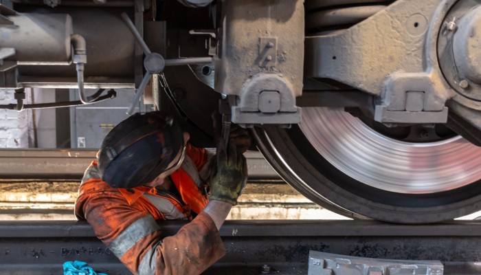 A ScotRail engineer working on a train wheel