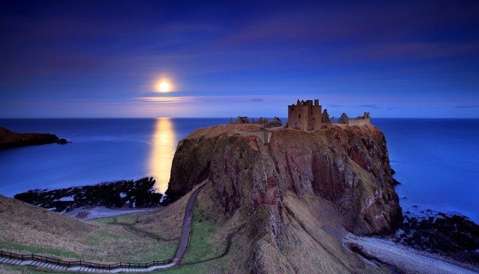 Dunnottar Castle in Aberdeenshire in the evening with moon shining bright