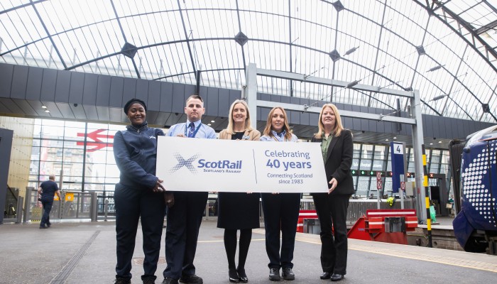 Left to right: Ajarata Barboe, ScotRail Customer Service Assistant; Paul Hay, ScotRail Customer Service Assistant; Joanne Maguire, ScotRail Chief Operating Officer; LesleyAnn McRavey, ScotRail Customer Service Assistant; Margaret Hoey, ScotRail Station General Manager, in Glasgow Queen Street station holding a banner which read "Celebrating 40 Years. Connecting Scotland since 1983"..