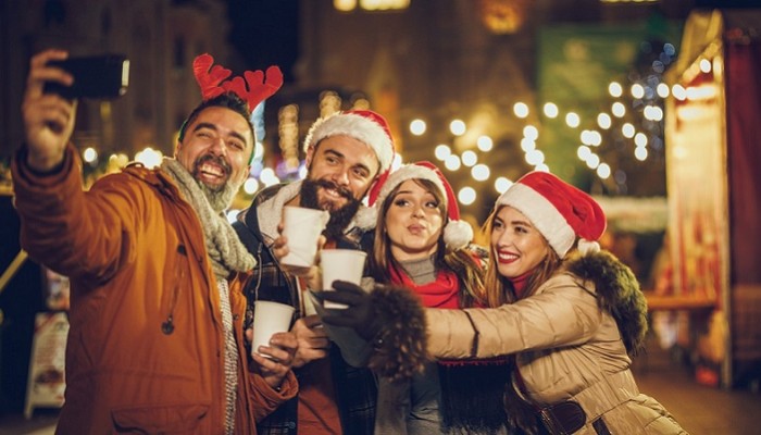 Four friends at the Christmas markets smiling for a selfie