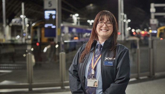 Female ScotRail staff member smiling in train station 
