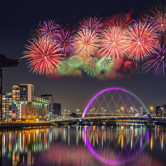 Glasgow city at night during festive period with fireworks in the sky