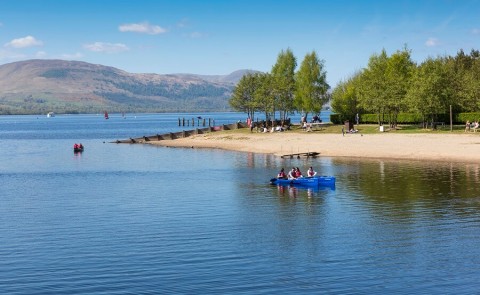 Loch Lomond waters and shore, with people in a pedalo 