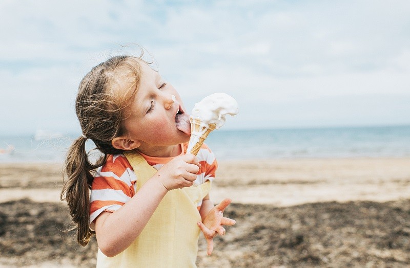 In content - little girl eating ice cream on the beach